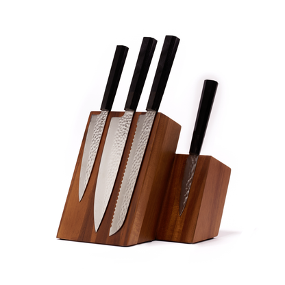 Set of four knives with black handles in a wooden block on a white background