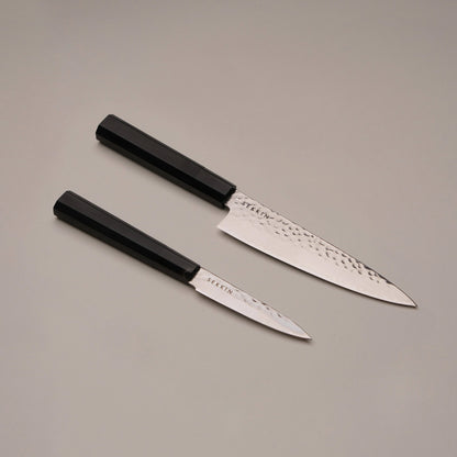 Two knives with black handles on a gray background