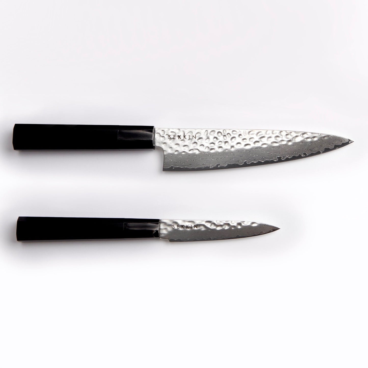 Two black-handled knives with silver blades on a white background